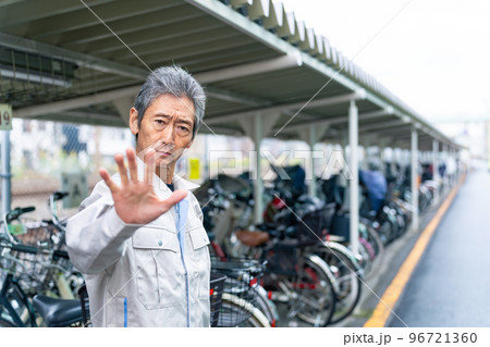 駐輪場で制止する管理者のシニア男性 96721360