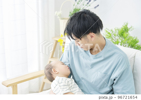 家で眠る赤ちゃんを抱っこする男性 96721654