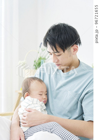 家で眠る赤ちゃんを抱っこする男性 96721655