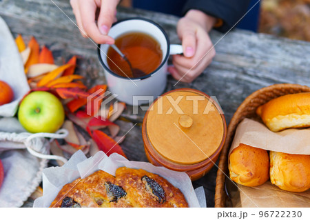 picnic in the autumn season, food on a wooden table, hot tea, pastries and sandwiches 96722230