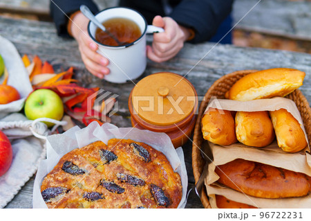 picnic in the autumn season, food on a wooden table, hot tea, pastries and sandwiches 96722231
