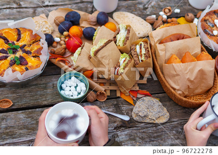 picnic in the autumn season, food on a wooden table, hot tea, pastries and sandwiches 96722278