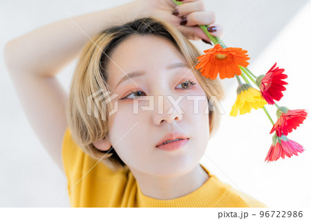 ガーベラを持った若い女性のポートレート 96722986