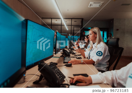 Group of female security operators working in a data system control room Technical Operators Working at workstation with multiple displays, security guards working on multiple monitors in surveillan 96723185