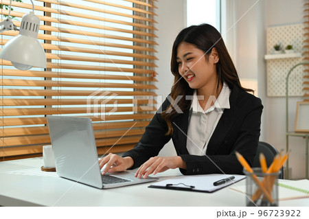 Beautiful asian female investor working online, analyzing financial online data on laptop computer Beautiful asian female investor working online, analyzing financial online data on laptop computer 96723922