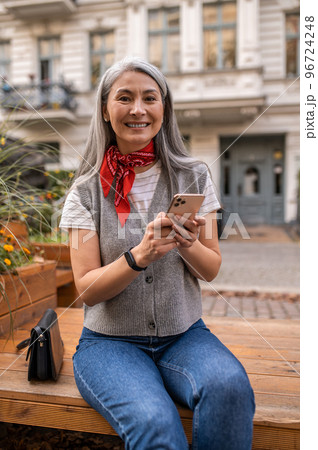 Long-haired woman sitting on the bench and waiting for someone 96724248