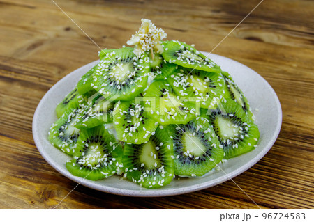 Christmas tree shaped fruit salad on wooden table. Creative idea for Christmas and New Year festive desserts. Funny food idea for kids Christmas tree shaped fruit salad on wooden table. Creative idea for Christmas and New Year festive desserts. Funny food idea for kids 96724583