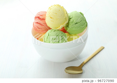 Bowl with ice cream scoops on white wooden table 96727090
