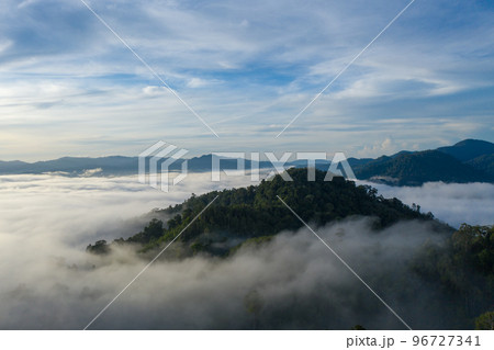 aerial view scenery sunrise above the mountain in tropical rainforest. slow floating fog blowing cover on the mountain look like as a sea of mist.  beautiful sunrise in the mist background. 96727341