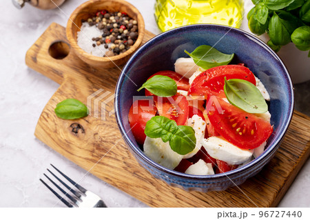 Caprese salad with ripe tomatoes, mozzarella and garden basil 96727440