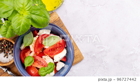 Caprese salad with ripe tomatoes, mozzarella cheese and garden basil Caprese salad with ripe tomatoes, mozzarella cheese and garden basil 96727442