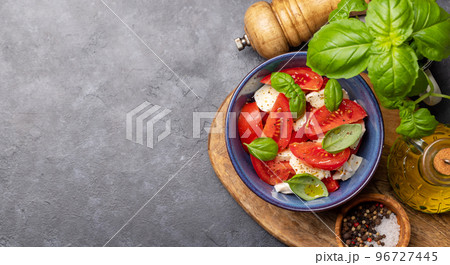 Caprese salad with ripe tomatoes, mozzarella cheese and garden basil Caprese salad with ripe tomatoes, mozzarella cheese and garden basil 96727445