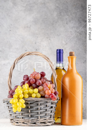 Ripe grape in basket and wine bottles 96727473