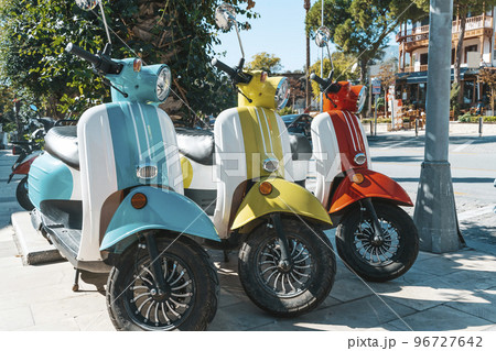 Scooter motorcycle on city street. Vintage classic retro scooters various bright colors on a sunny tourist street. Lifestyle, retro concept. 96727642
