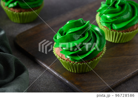 Chocolate cupcakes with green whipped cream and chocolate sprinkles. Chocolate cupcakes with green whipped cream and chocolate sprinkles. 96728586