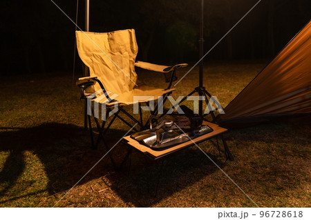 キャンプ場でランタンの光で照らされる椅子 96728618