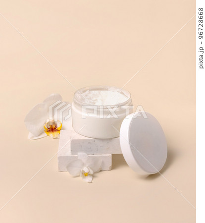 Opened Cream jar with a blank lid near orchid flowers on light yellow close up. Cosmetic Mockup Opened Cream jar with a blank lid near orchid flowers on light yellow close up. Cosmetic Mockup 96728668