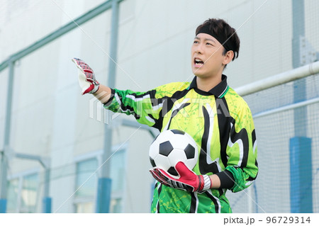 サッカーボールをキャッチするゴールキーパーの男性 96729314