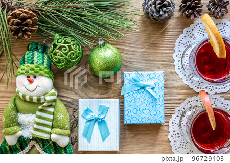 Hot mulled wine with spices on wooden background. Christmas tree branches, gifts and cones. Hot mulled wine with spices on wooden background. Christmas tree branches, gifts and cones. 96729403
