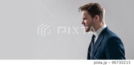 Angry business professional man stand sideway in anger grey background copy space, boss. Man face portrait, banner with copy space. Business man in suit, isolated studio background, banner poster. Angry business professional man stand sideway in anger grey background copy space, boss. Man face portrait, banner with copy space. Business man in suit, isolated studio background, banner poster. 96730215