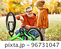 grandfather and grandson repair bicycle outdoors in the autumn park 96731047