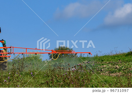 A tractor with a tank and attached equipment for spraying the field from pests and weeds, the process of processing the field. A tractor with a tank and attached equipment for spraying the field from pests and weeds, the process of processing the field. 96731097