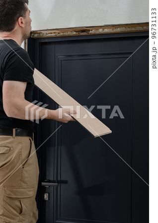 Checking the door frame for evenness of the surface after installation using a metal rule. Checking the door frame for evenness of the surface after installation using a metal rule. 96731133