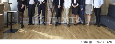 Banner image of legs of different business people standing in row in modern loft office. 96731326