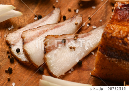 still life of food in a rural style on a dark wood background, sliced lard and garlic, salt and pepper, concept of fresh vegetables and healthy food 96732516