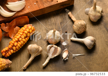still life of food in a rural style on a dark wood background, corn and garlic, concept of fresh vegetables and healthy food still life of food in a rural style on a dark wood background, corn and garlic, concept of fresh vegetables and healthy food 96732533