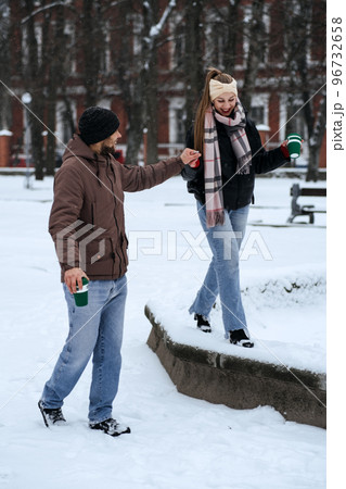 Winter Date Ideas to Cozy Up. Cheap First-Date Ideas for Winter Love dating outdoors. Cold season dates for couples. Young couple in love hugging and kissing in winter street and park. 96732658