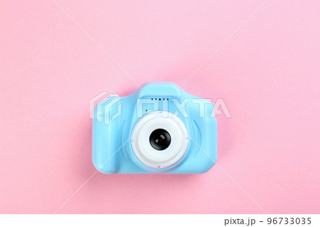 Light blue toy camera on pink background, top view Light blue toy camera on pink background, top view 96733035