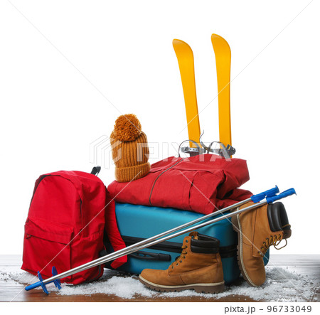 Suitcase with warm clothes and skis isolated on white. Winter vacation 96733049