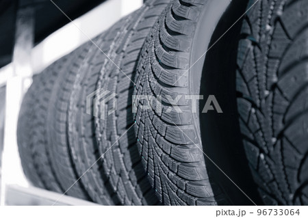 Tires on rack in car service workshop, closeup Tires on rack in car service workshop, closeup 96733064