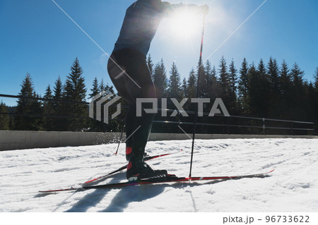 Nordic skiing or Cross-country skiing classic technique practiced by man in a beautiful panoramic trail at morning. 96733622