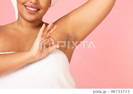 Cropped shot of black obese woman showing her smooth armpit and ok gesture, positive lady lifting hand, pink background 96733715