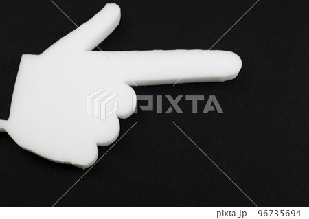a hand made of foam rubber with an index finger on a black background. a hand made of foam rubber with an index finger on a black background. 96735694