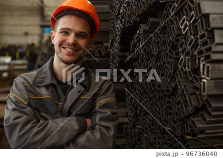 Portrait of cheerful worker posing on metal stock 96736040