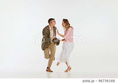 Young excited man and woman in 60s american fashion style clothes dancing retro dance isolated on white background. Music, energy, happiness, mood, action 96736166