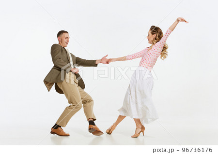 Two emotional dancers in vintage style clothes dancing swing dance, rock-and-roll or lindy hop isolated on white background. 1960s american fashion style and art. Two emotional dancers in vintage style clothes dancing swing dance, rock-and-roll or lindy hop isolated on white background. 1960s american fashion style and art. 96736176
