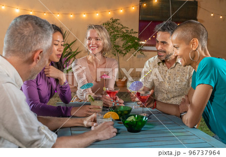 Group of cheerful friends at night party drinking cocktails and having fun together. Smiling people enjoying nightlife drinking alcoholic beverages. Group of cheerful friends at night party drinking cocktails and having fun together. Smiling people enjoying nightlife drinking alcoholic beverages. 96737964