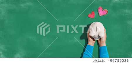 Person holding piggy bank with hearts Person holding piggy bank with hearts 96739081