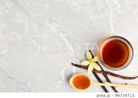 Flat lay composition with vanilla extract on light grey marble table ...