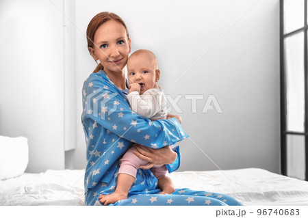 Young woman with her little baby resting after breast feeding in bedroom 96740683