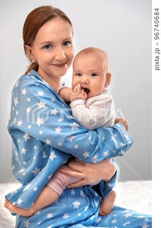 Young woman with her little baby resting after breast feeding on bed 96740684