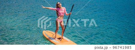 BANNER, LONG FORMAT Young women Having Fun Stand Up Paddling in blue water sea in Montenegro. SUP. girl Training on Paddle Board near the rocks Portrait of a disgruntled girl sitting at a cafe table 96741985