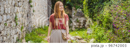 BANNER, LONG FORMAT Woman tourist walks through the old town of Bar in Montenegro. Happy tourist walks in the mountains. Suburbs of the city of Bar, Montenegro, Balkans. Beautiful nature and landscape 96742003