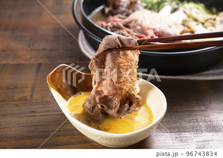 すき焼きの肉を卵につける 96743834