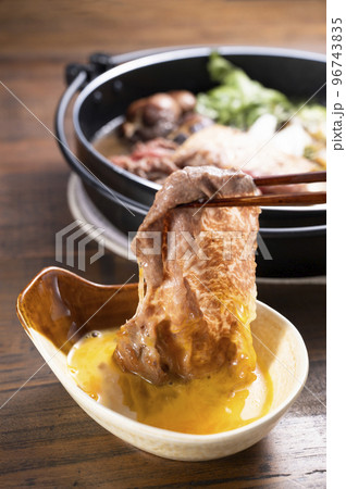 すき焼きの肉を卵につける すき焼きの肉を卵につける 96743835