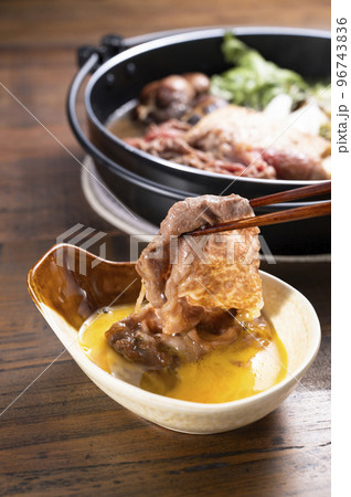 すき焼きの肉を卵につける 96743836